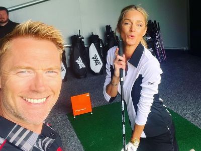 Storm Keating is posing with the golf stick as Ronan Keating is taking a selfie.